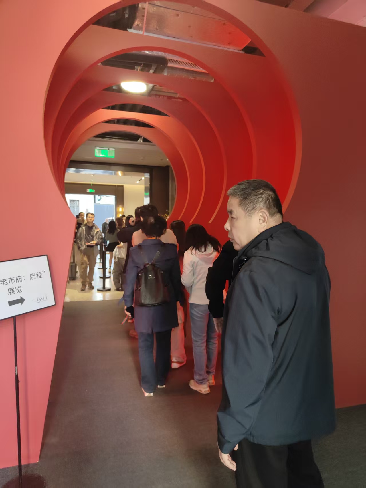 High-resolution project photo showing visitors queueing through the red entrance sequence of the Dalí exhibition